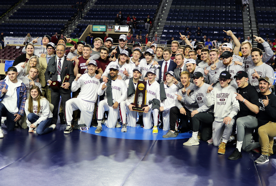 The entire wrestling team takes a group photo with their new trophy